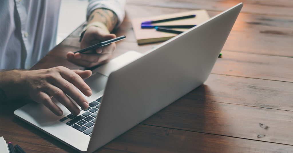 man typing on laptop
